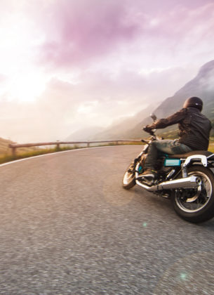 Motorcycle driver riding in through mountain ranges