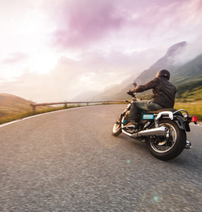 Motorcycle driver riding in through mountain ranges