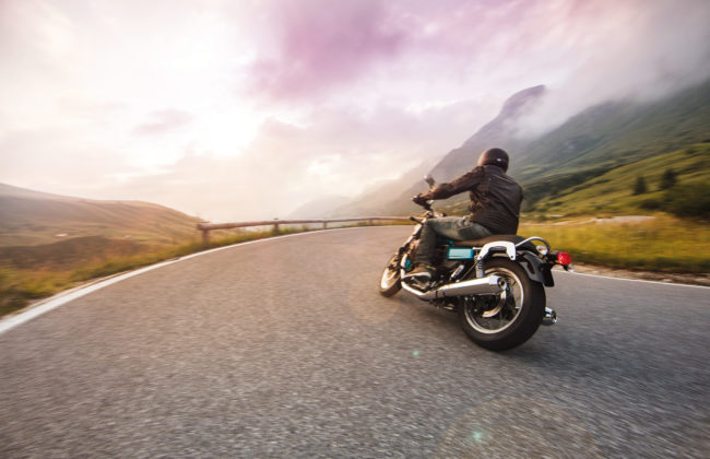 Motorcycle driver riding in through mountain ranges