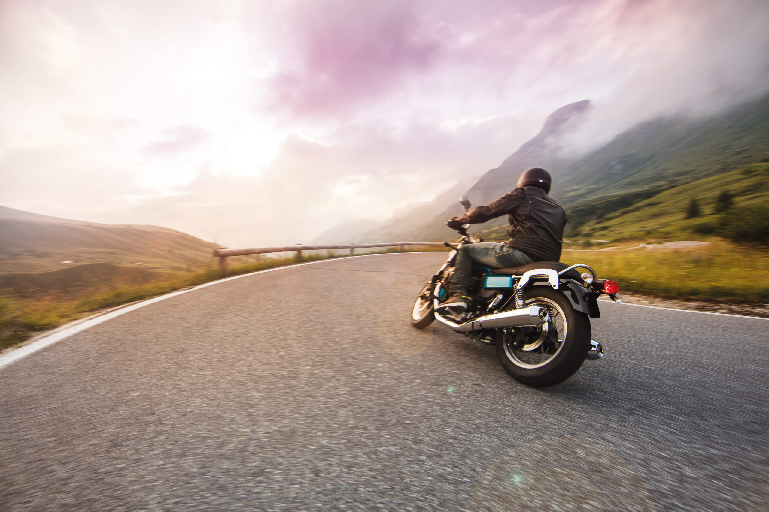 Motorcycle driver riding in through mountain ranges