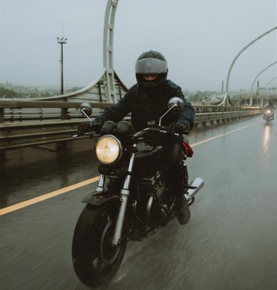 Blurred motorcyclist riding in the rain