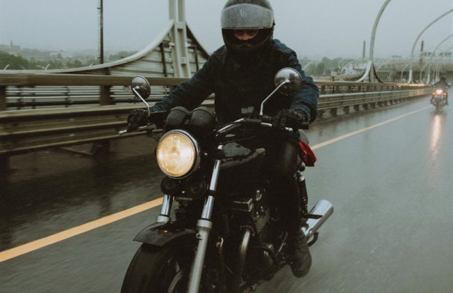 Blurred motorcyclist riding in the rain