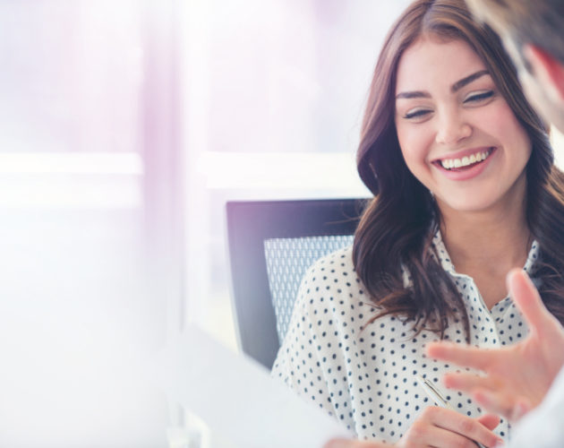 Businessman business woman working together. He looks like he is talking. She is smiling, laughing and happy