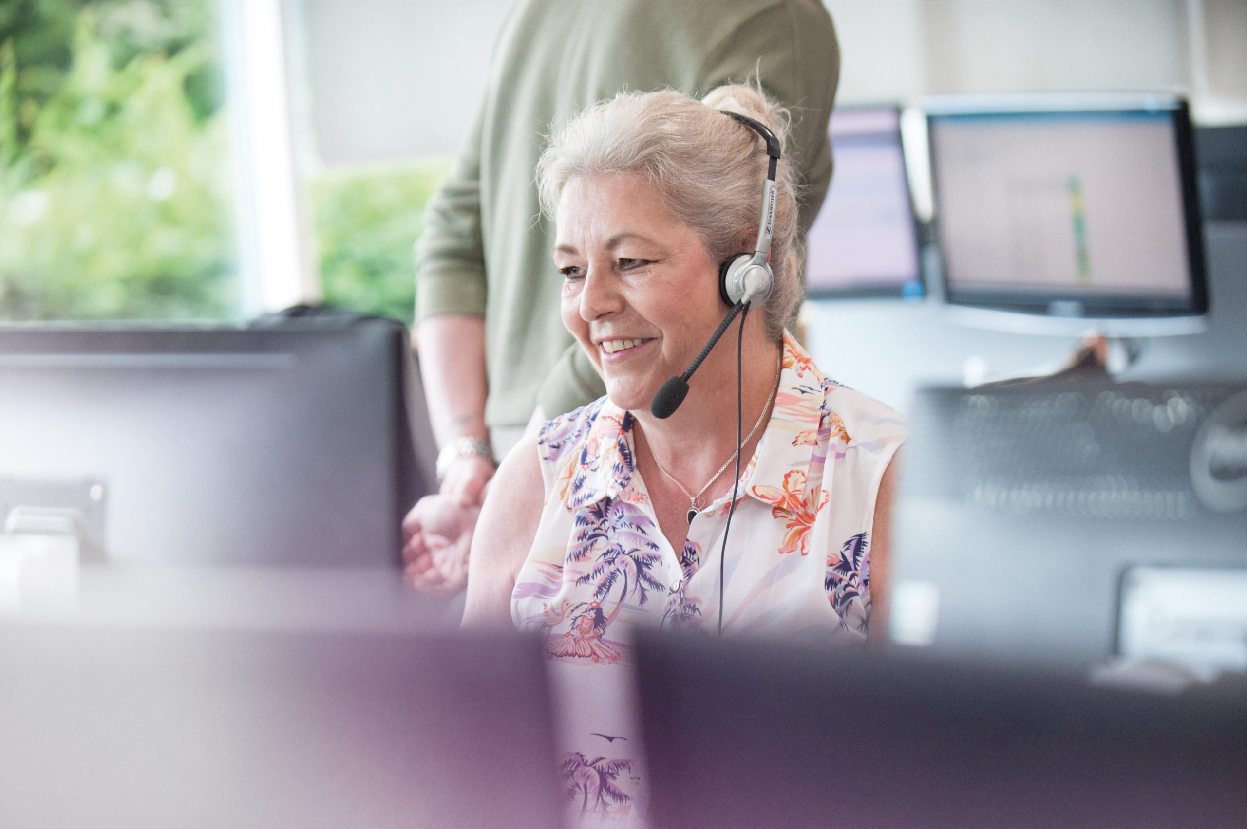 Woman in an office talking to a customer through a head set