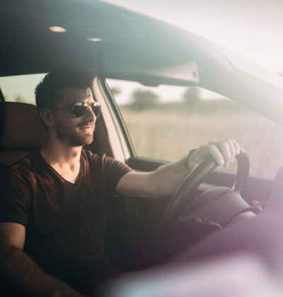 Man in sunglasses drives a car