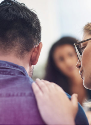 Person consoling another during a counseling session with a therapist