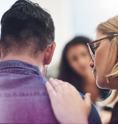 Person consoling another during a counseling session with a therapist