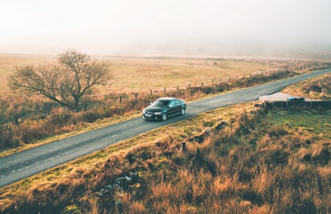 Car driving down an English country road