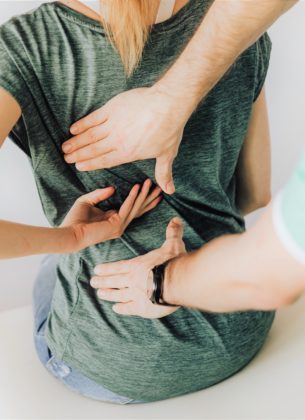 Physiotherapist takes care of a woman with back pain
