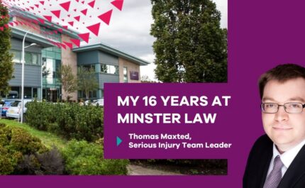 Promotional banner showing a modern office building with trees, landscaped greenery and parked cars on the left. On the right, a purple panel features a professional headshot of a person wearing glasses, a suit and tie. White text reads: “MY 16 YEARS AT MINSTER LAW” with smaller text below: “Thomas Maxted, Serious Injury Team Leader.” A red triangular graphic pattern appears at the top.