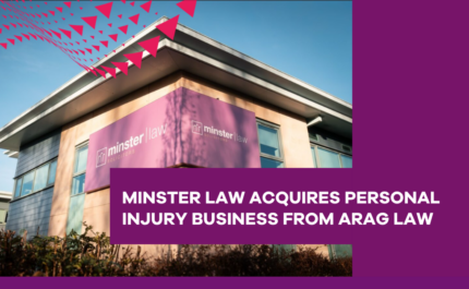 Exterior view of a modern office building displaying Minster Law branding on a large purple sign. A purple banner overlay contains the text: “MINSTER LAW ACQUIRES PERSONAL INJURY BUSINESS FROM ARAG LAW.” The image features a blue sky background with a decorative pattern of pink triangular shapes in the top left corner and a purple branded panel on the right-hand side.